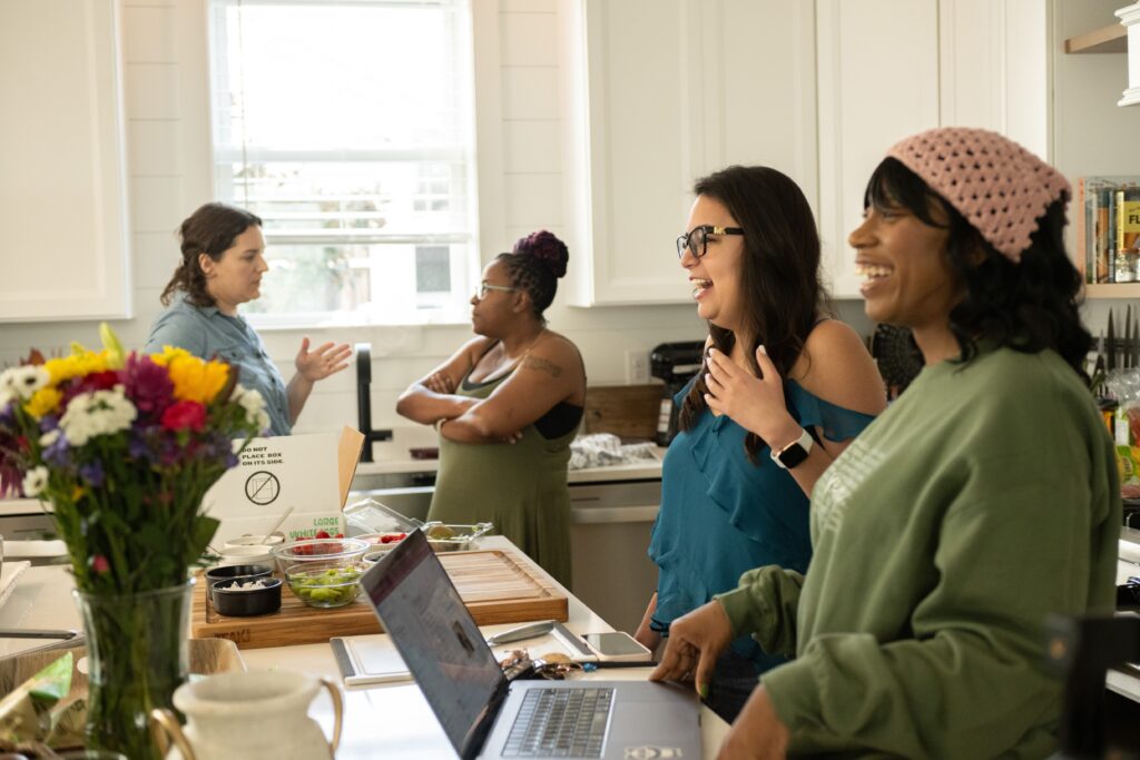 women laughing in the kitchen at a photography retreat
